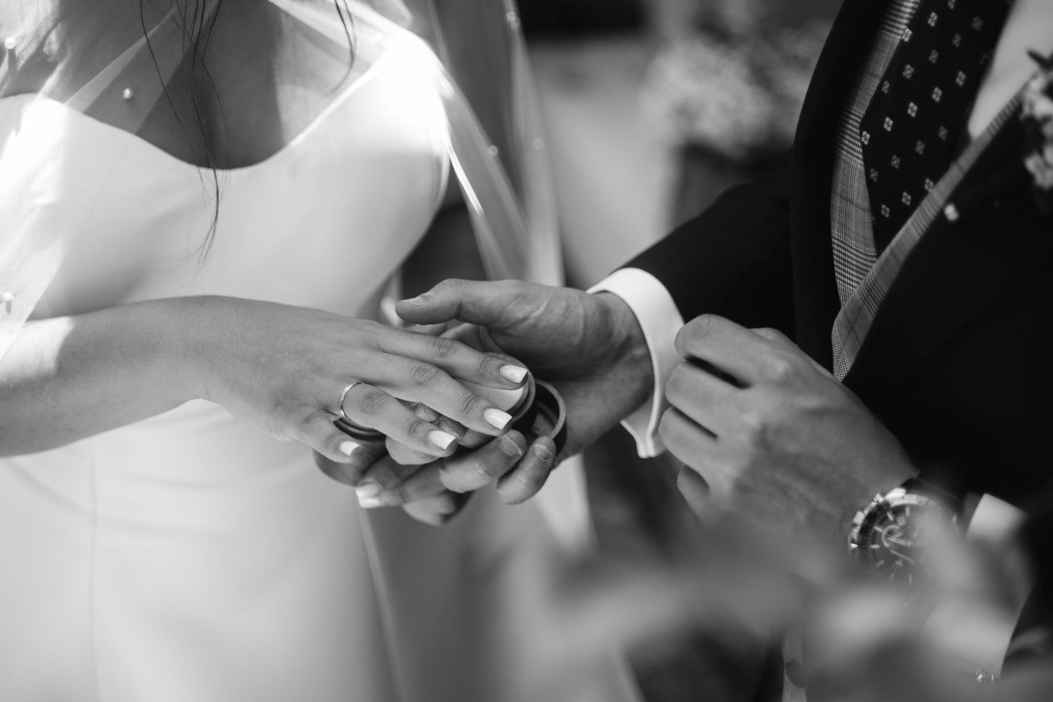 Close-up shot of hands exchanging wedding rings during a romantic ceremony.