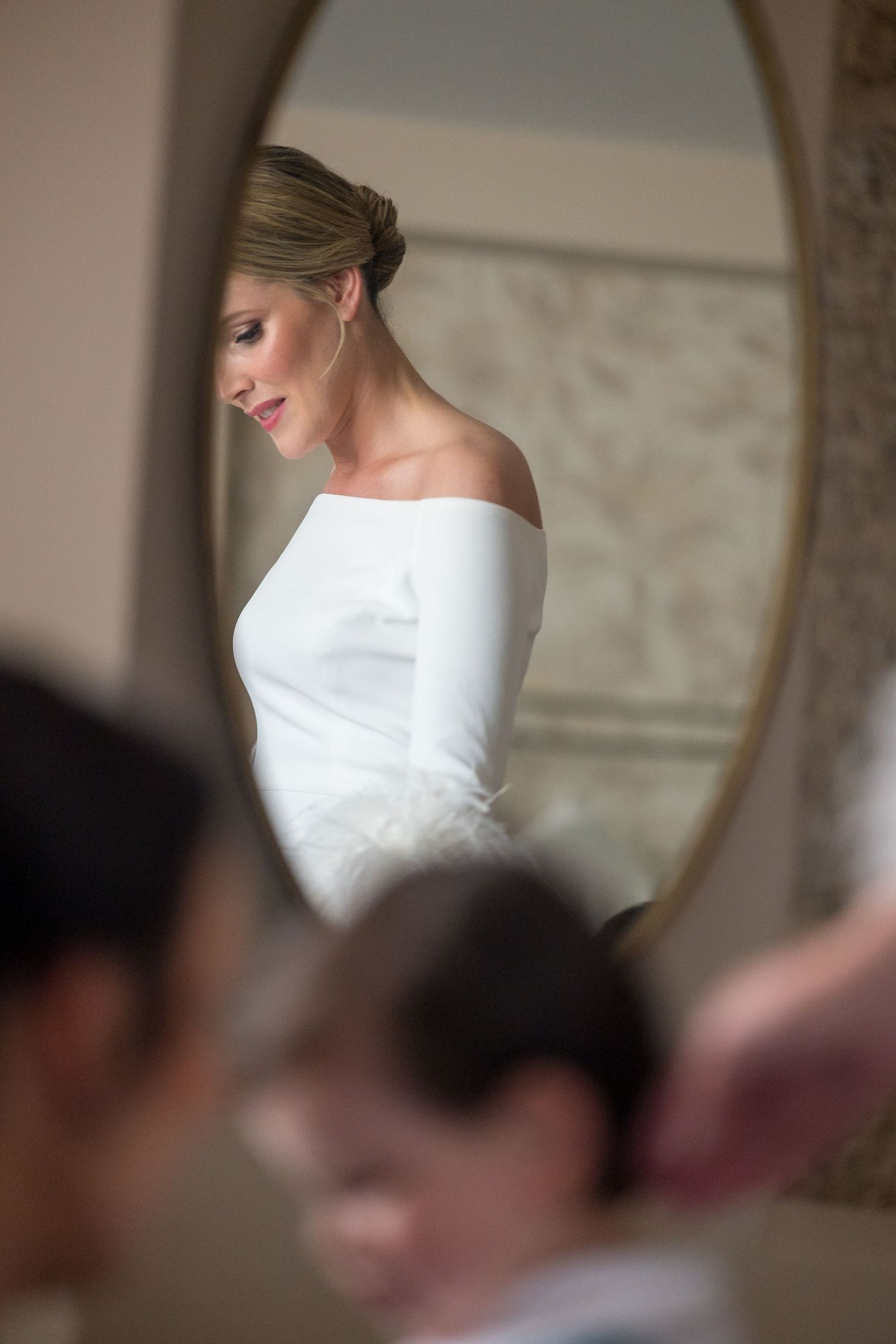 Close-up view of a white wedding dress bodice with off-shoulder design.