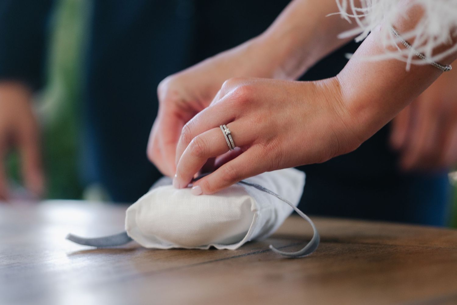 Close-up of hands placing wedding rings during a ceremony.