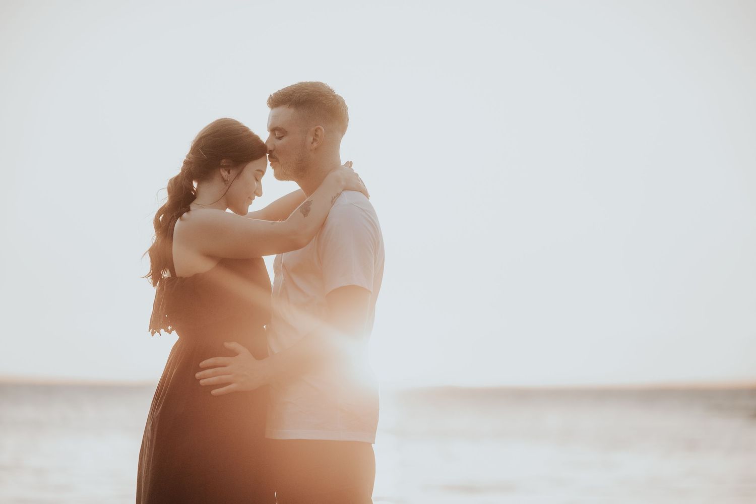 Couple embracing in bright sunlit room with romantic atmosphere.