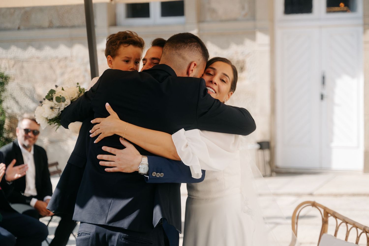 Wedding guests share emotional embraces and dance together during reception celebrations at an elegant venue.