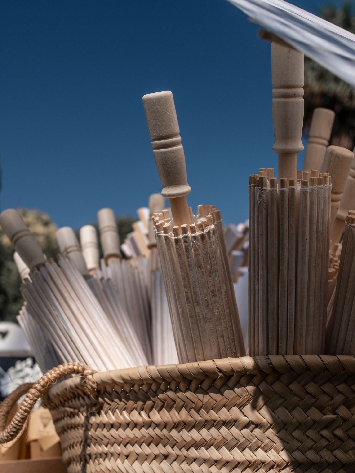 Close-up sequence of wooden deck railing posts with intricately woven rope pattern against blue sky background.