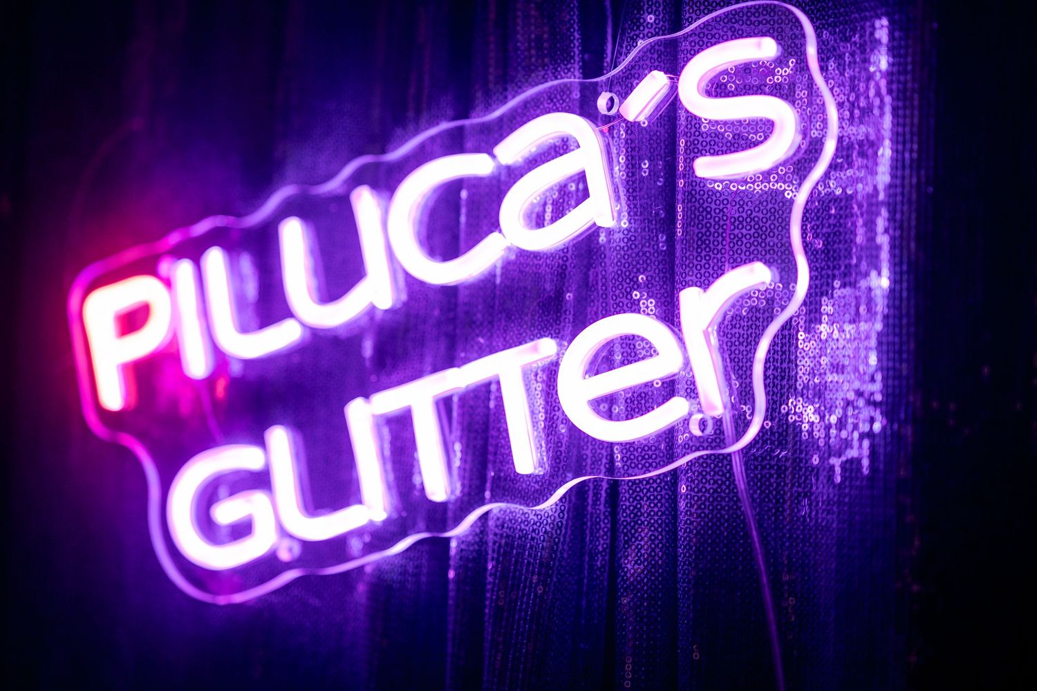 Purple neon text signs glowing in sequence against dark background.