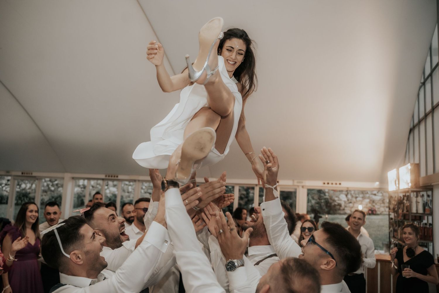Guests lift and celebrate with the bride and groom during an energetic wedding reception dance.
