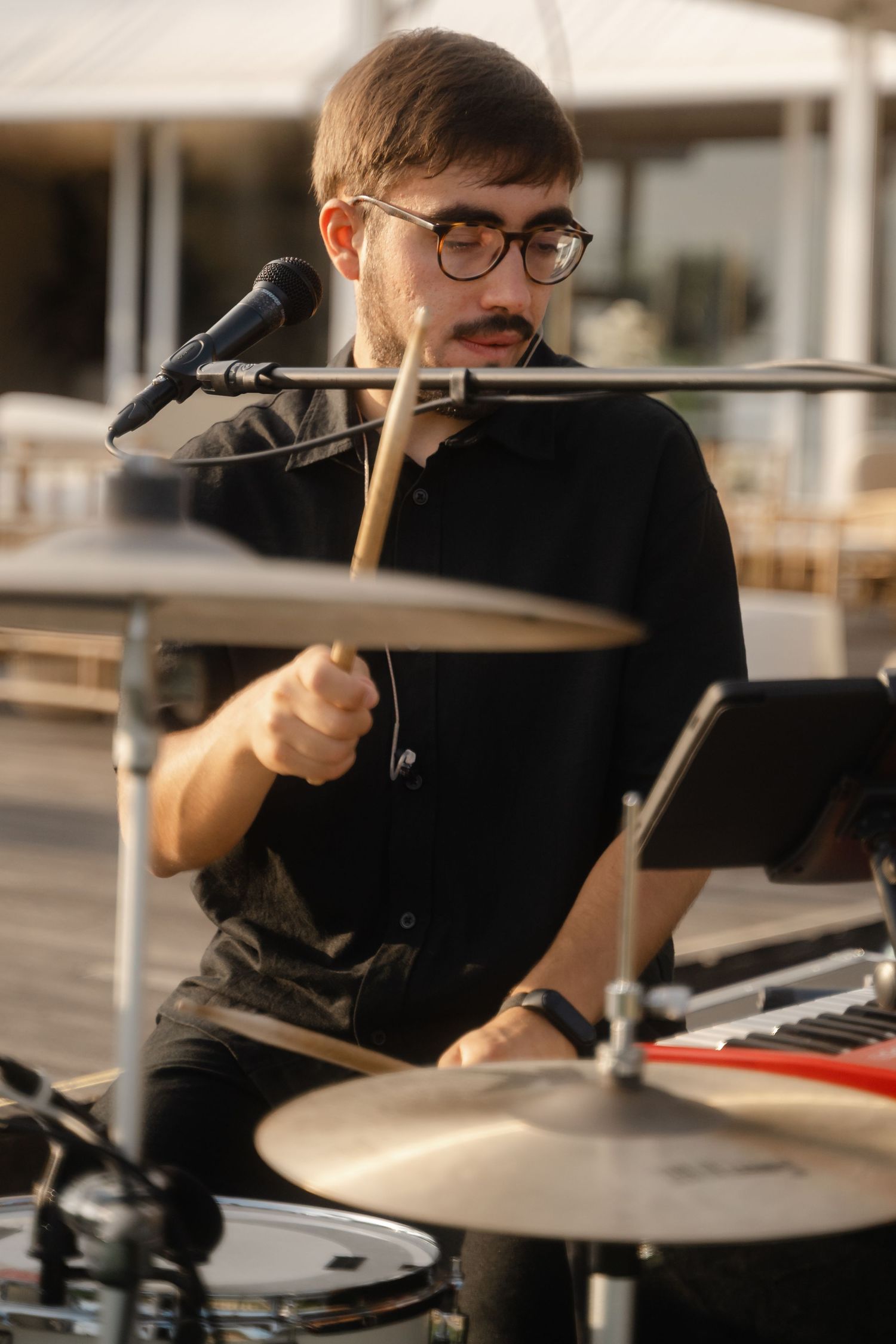 Musicians playing drums and instruments during a live performance.