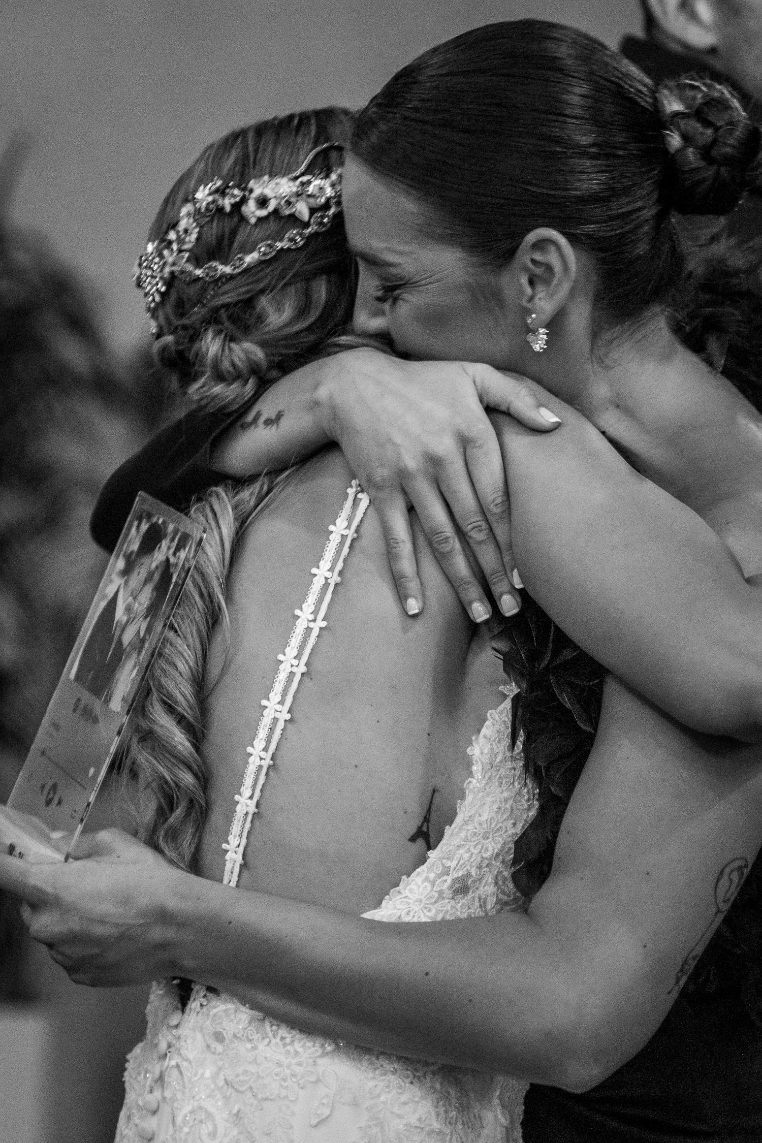 Black and white wedding photos capture tender embraces between newlyweds during their reception celebration.