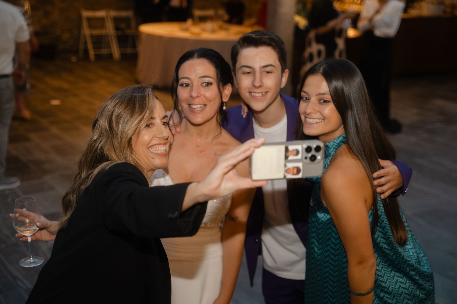 A group of party guests gather together to take a selfie at a celebration event.