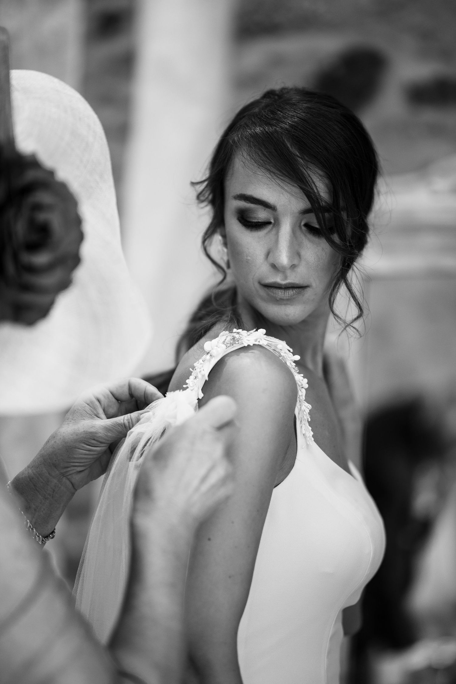 A black and white photo series showing a bride in an elegant white dress with delicate lace details.