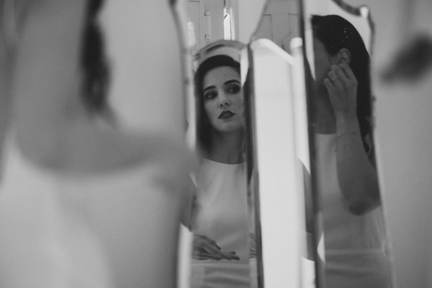 A black and white artistic photograph showing a reflection in a mirror with soft, dreamy lighting.