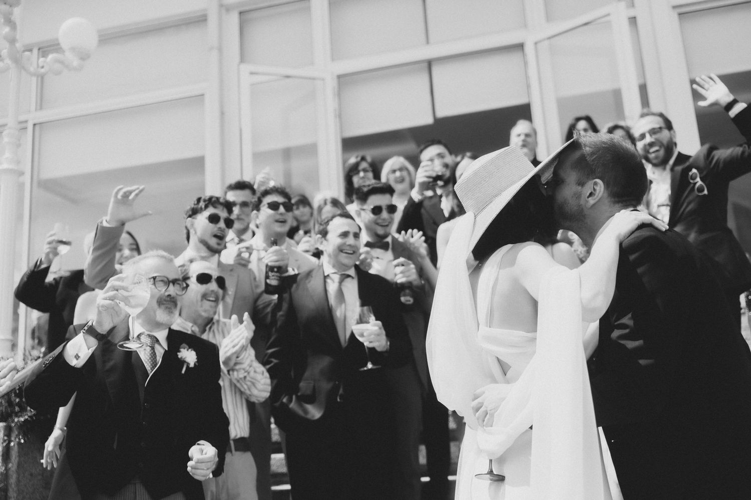 Wedding guests raise their glasses in celebration during an outdoor reception toast.