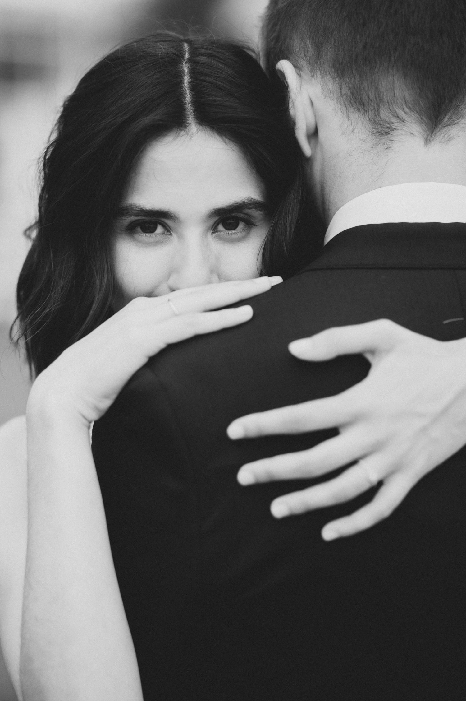 Black and white intimate close-up shots of a couple embracing in an emotional moment.