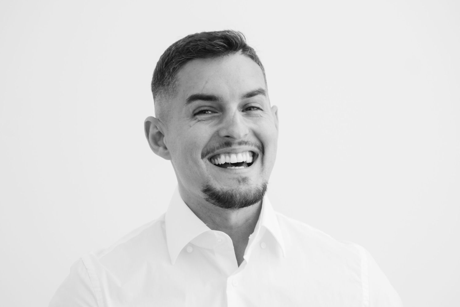 A collection of monochrome headshots capturing candid expressions and emotions against a clean white backdrop.