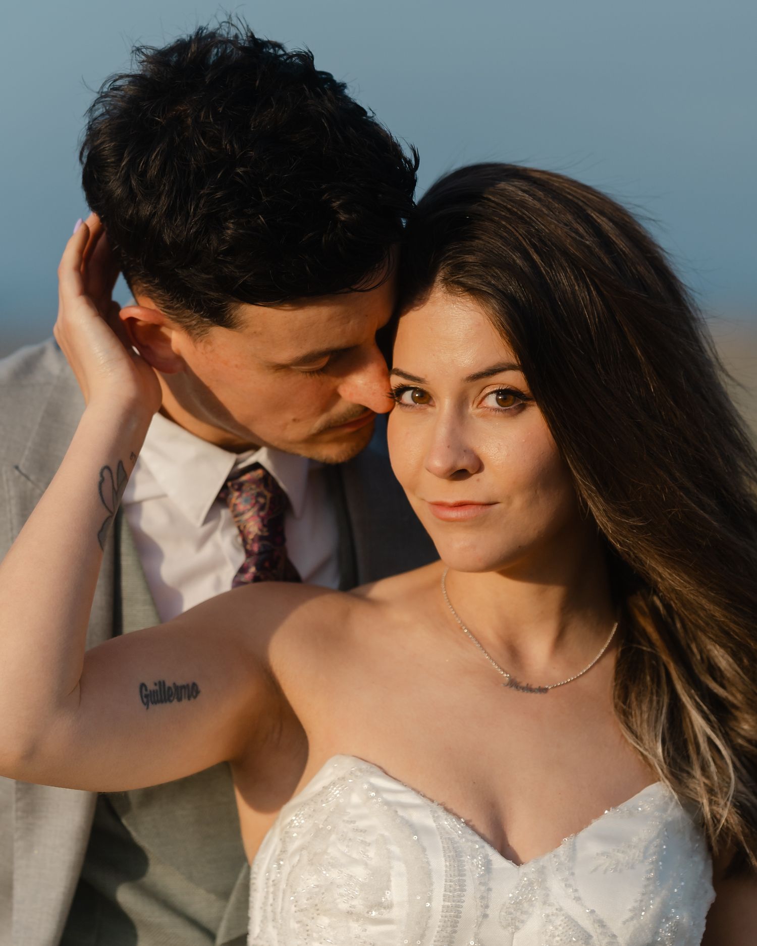 Close romantic portrait of bride and groom with golden hour lighting on their wedding day.