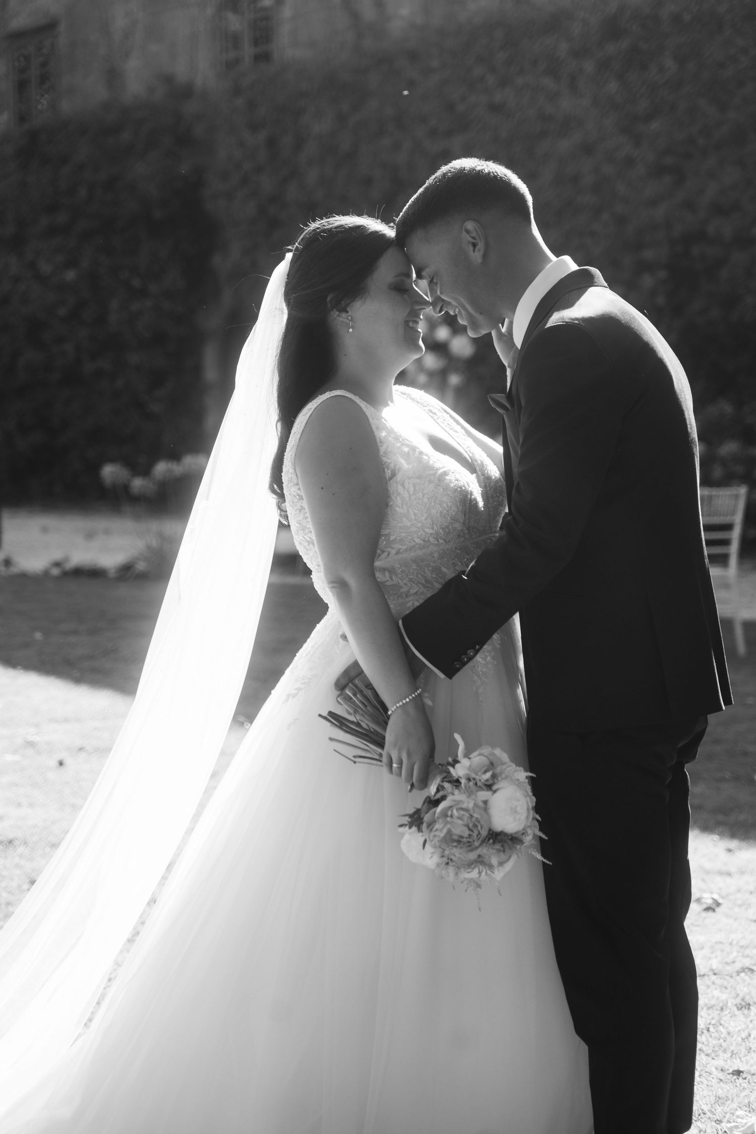 A romantic black and white wedding photo series showing a couple in an intimate moment with a flowing white dress.