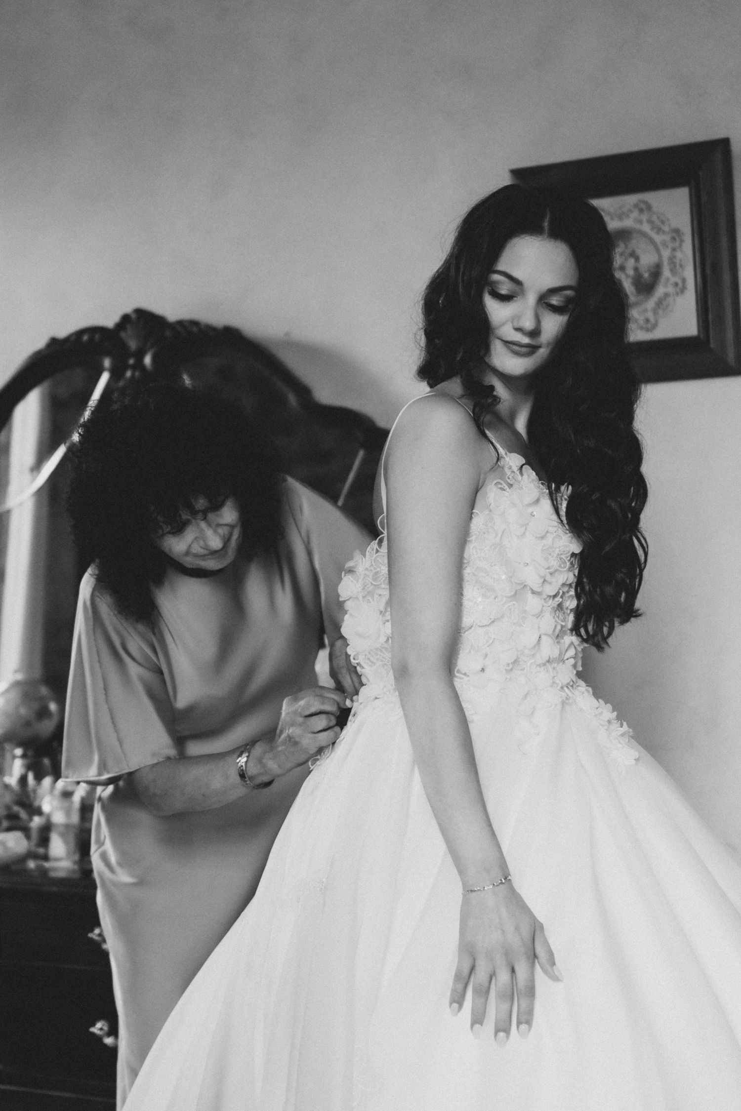 A series of black and white photos showing details of a bride getting ready in her white wedding dress.
