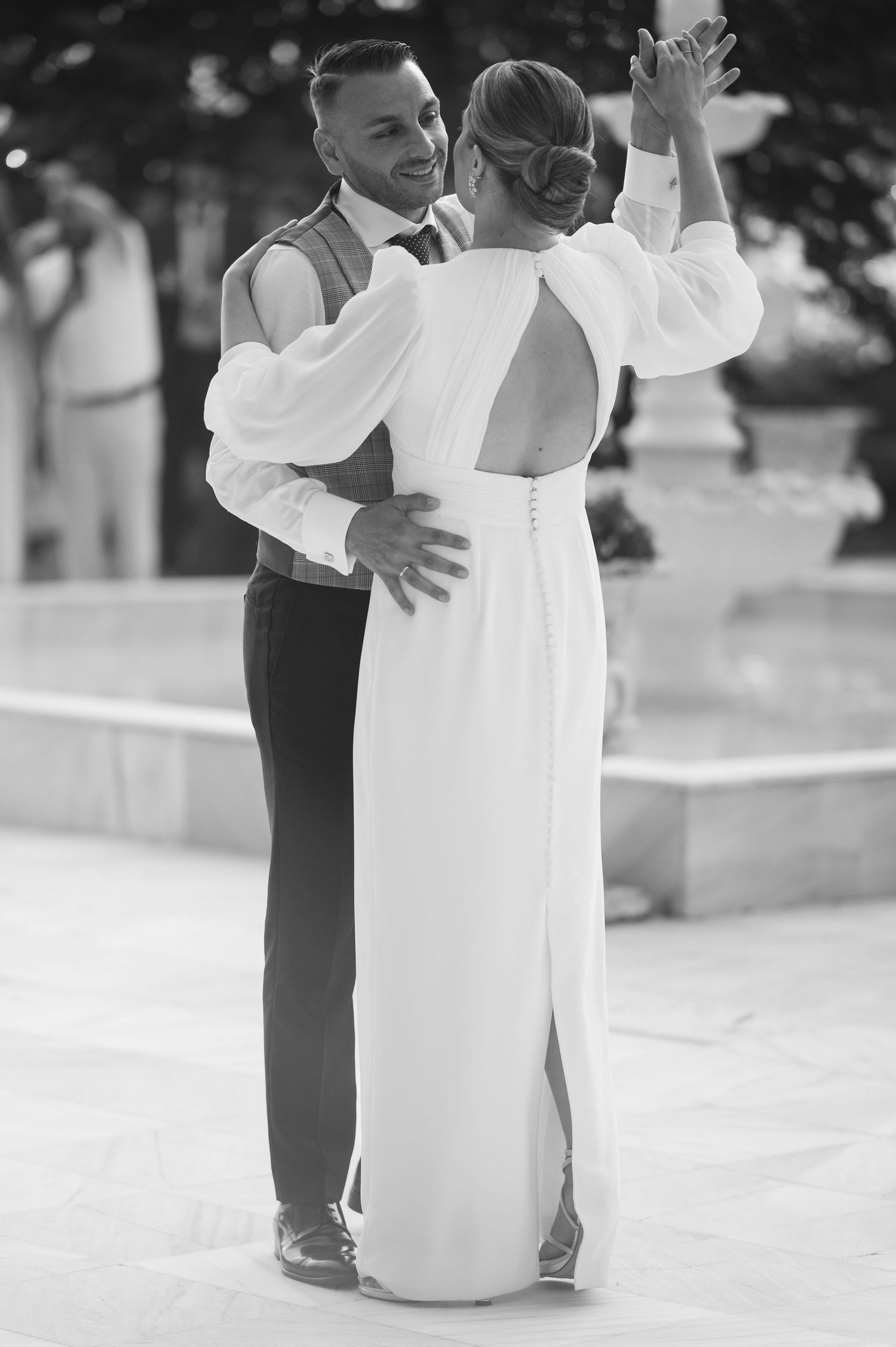 A black and white sequence of photos showing a couple in formal attire dancing together in an intimate embrace.