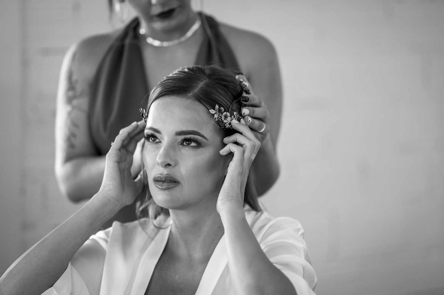 A black and white collage of bridal preparation moments showing styling, makeup application and final touches.