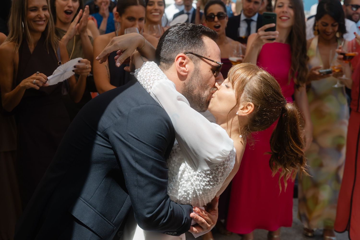 A happy couple shares their first dance as newlyweds while wedding guests watch and celebrate.