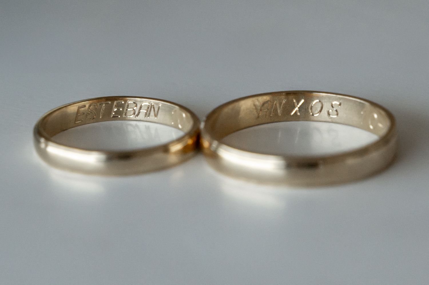 Close-up view of gold wedding rings photographed from different angles showing simple classic band designs.