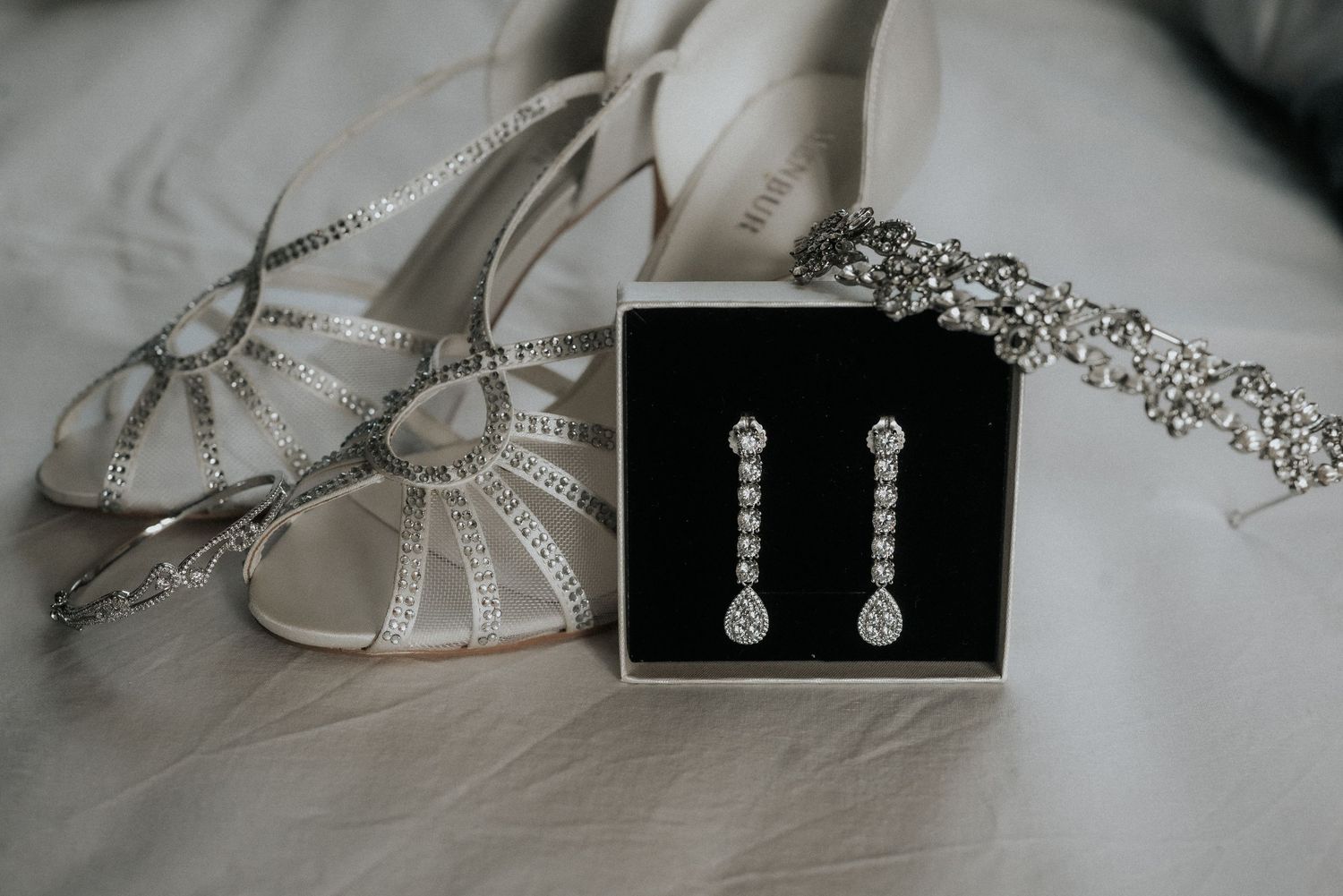 Wedding accessories including jewelry and hairpieces arranged on a light surface.