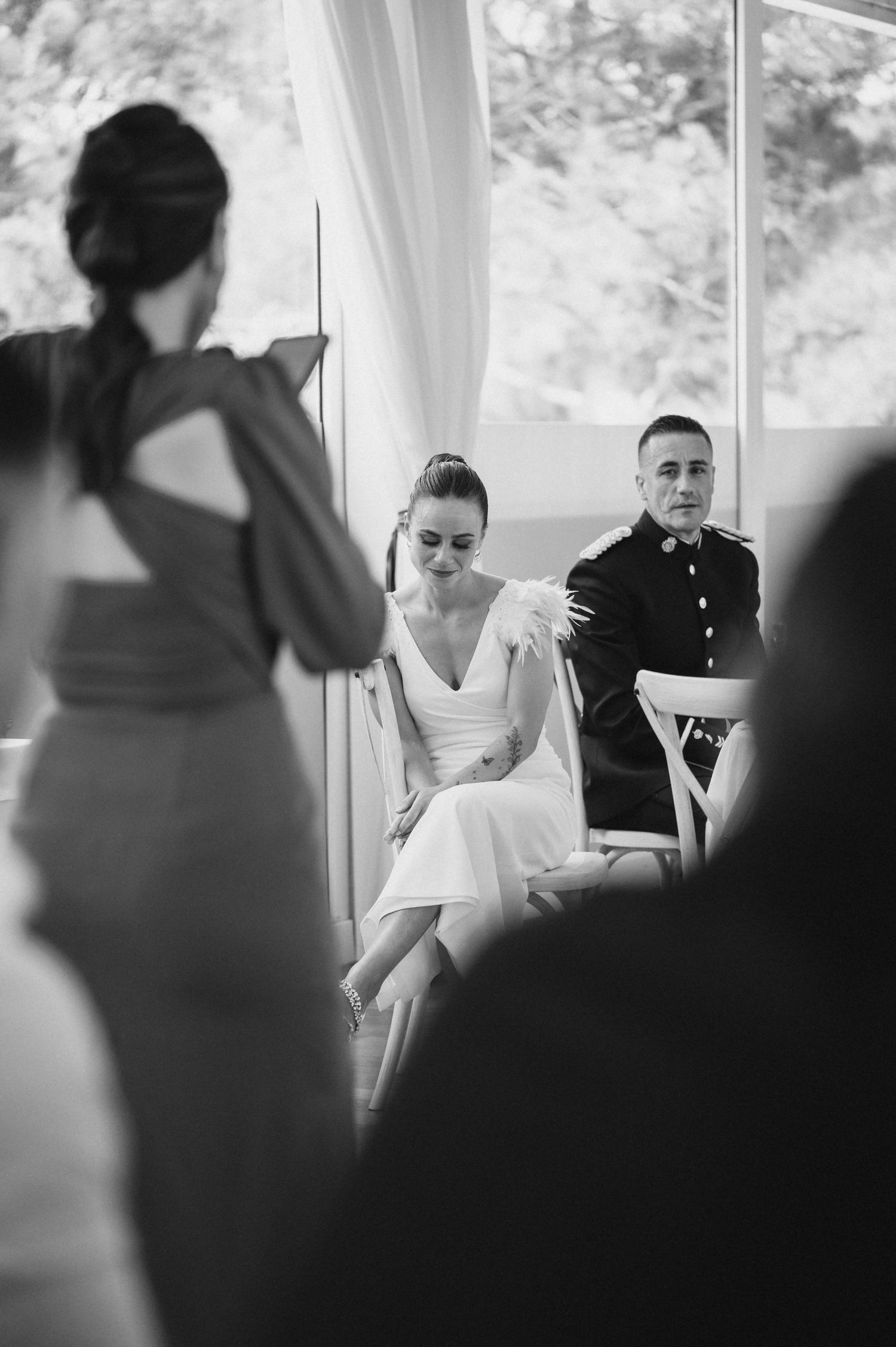 Black and white wedding photos show candid moments between a bride and groom during their ceremony.