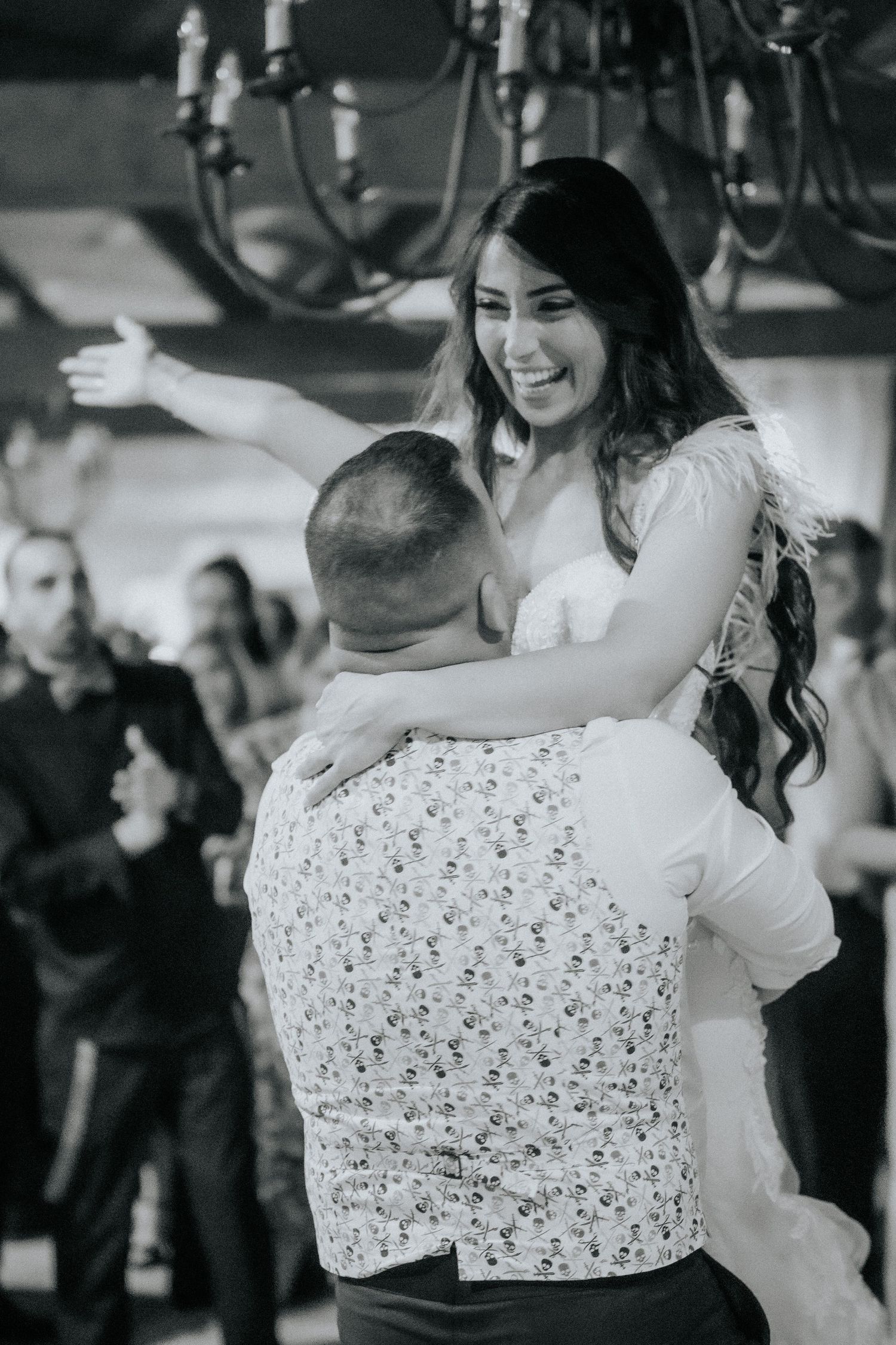 A couple shares an intimate dance moment at a wedding reception in black and white photography.