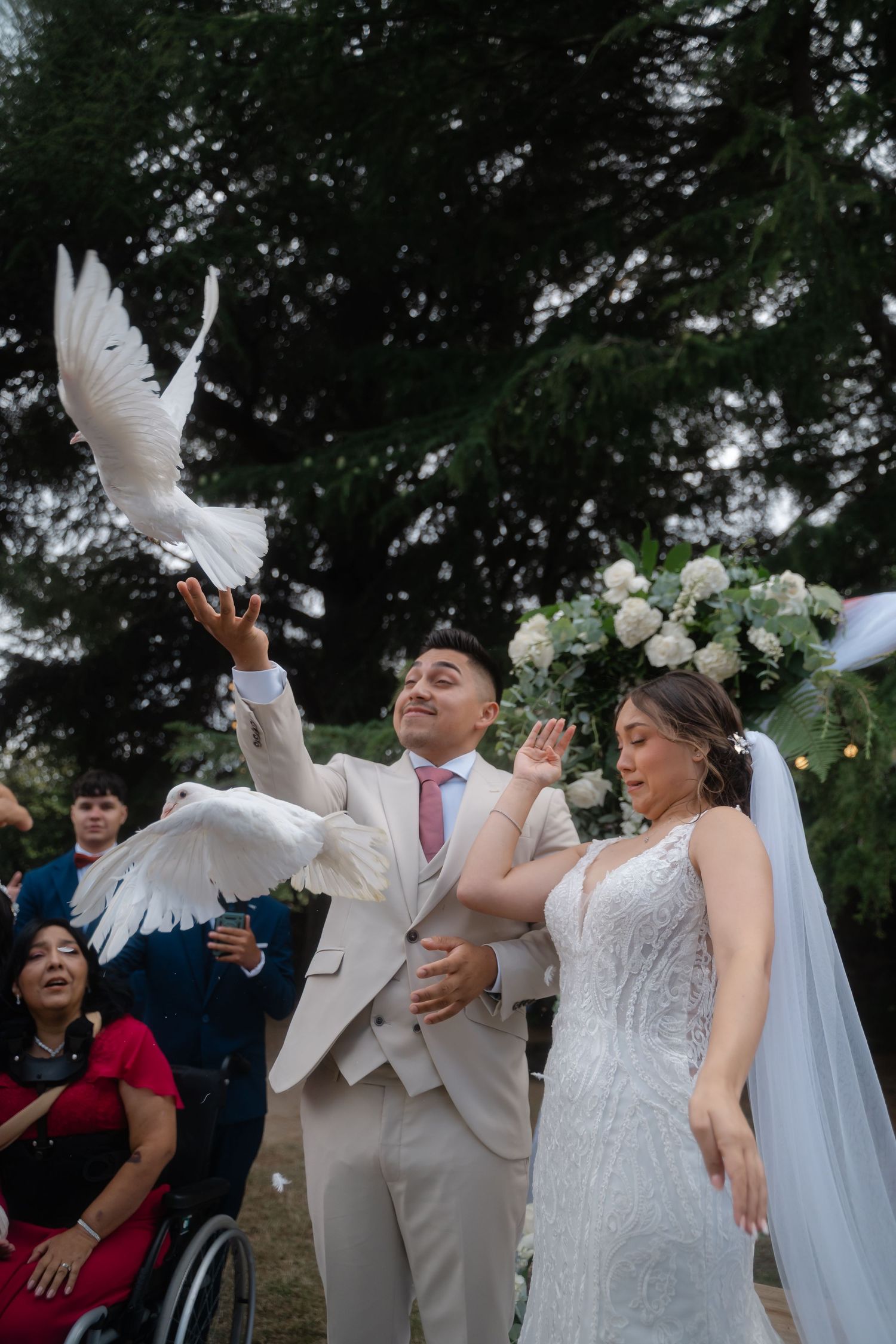 A sequence of photos showing a couple releasing white doves during their wedding ceremony outdoors.