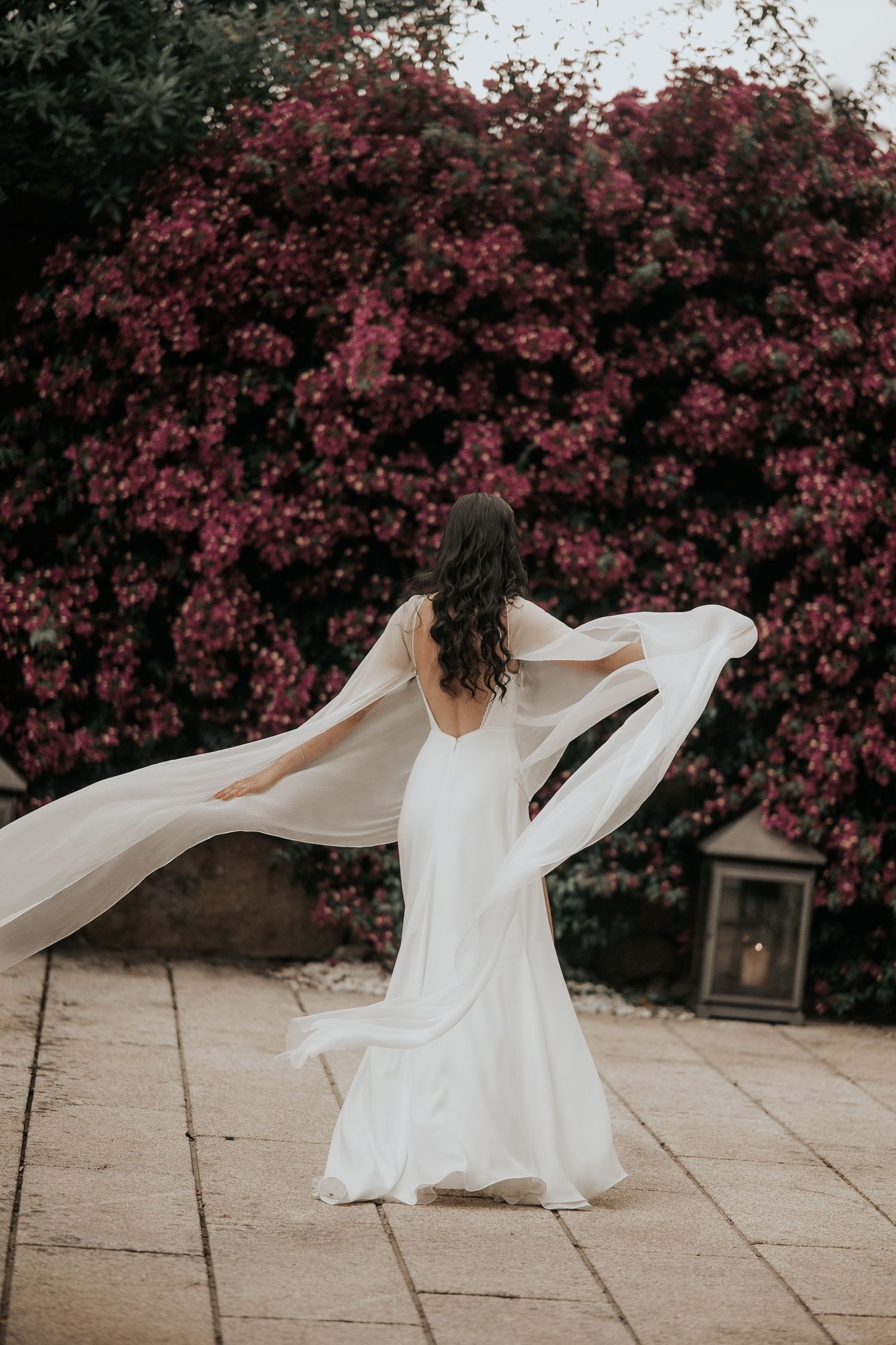 A flowing white dress twirls gracefully against a backdrop of vibrant pink flowering trees in a series of artistic shots.