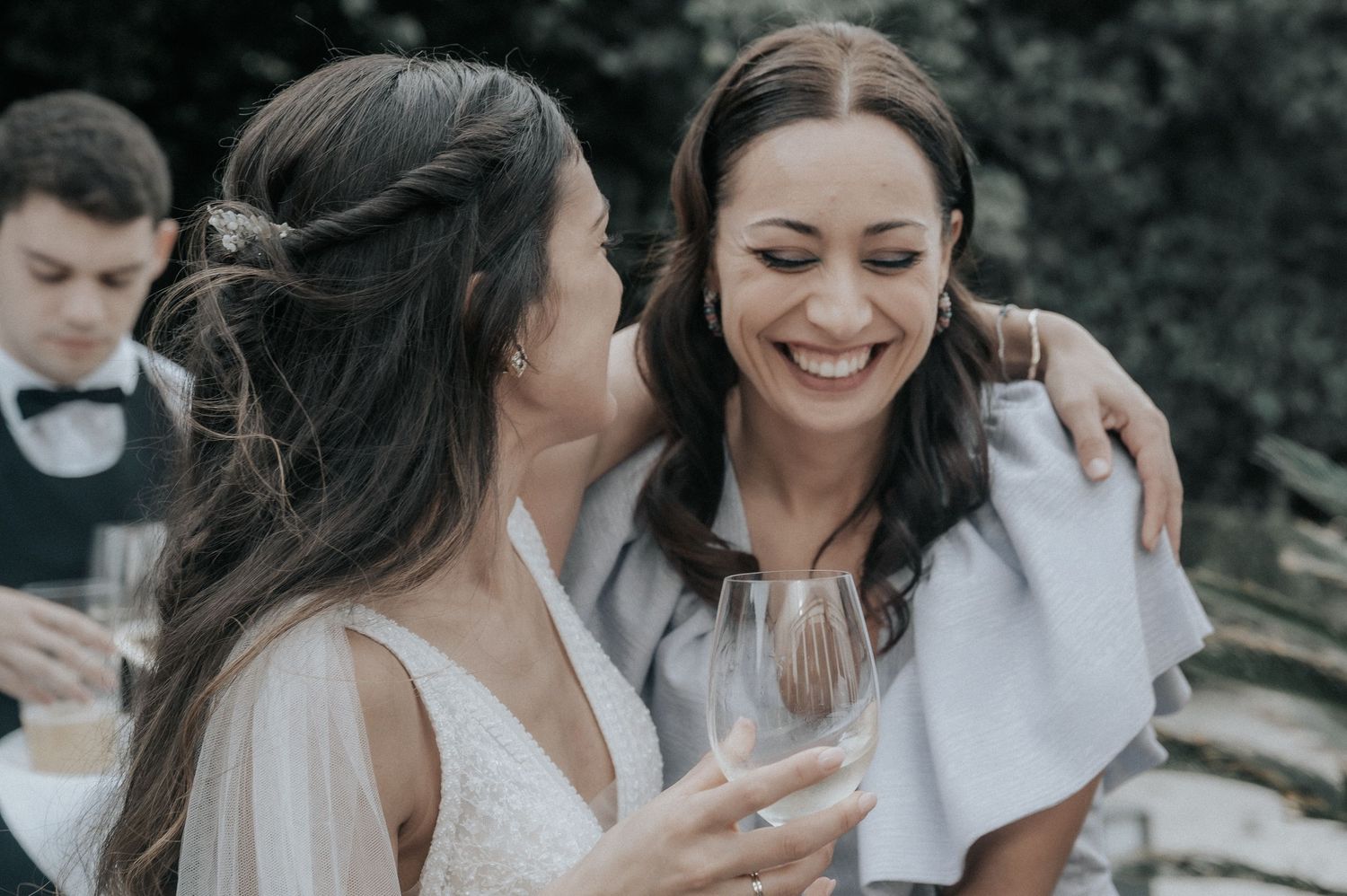 People celebrating outdoors in casual white attire during a sunny day.