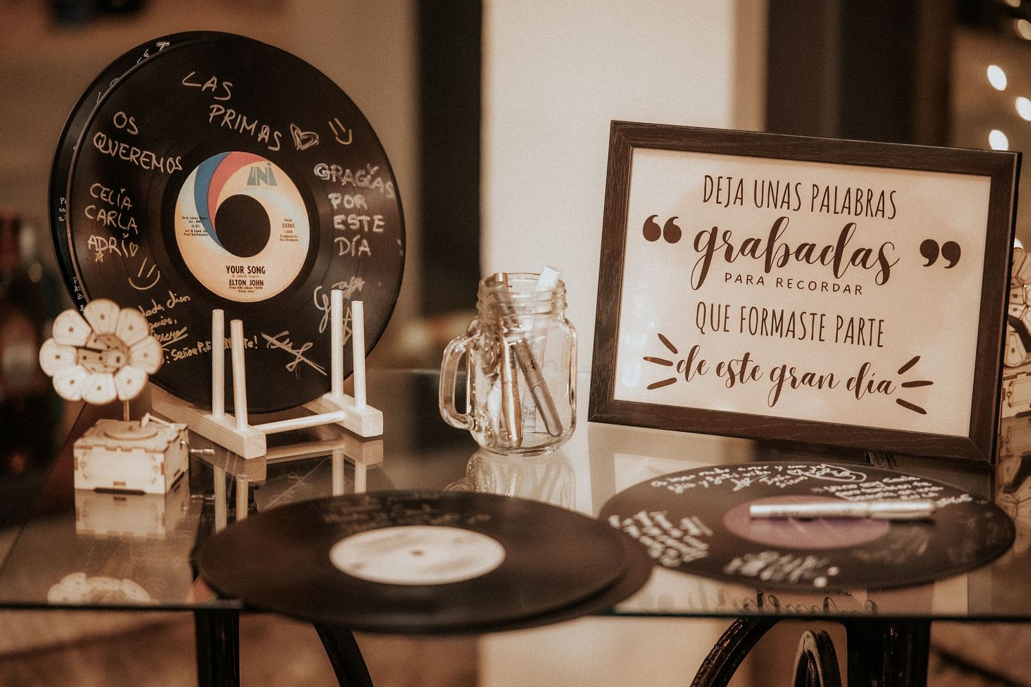 Vintage vinyl records and decorative signs displayed at a rustic wedding reception.