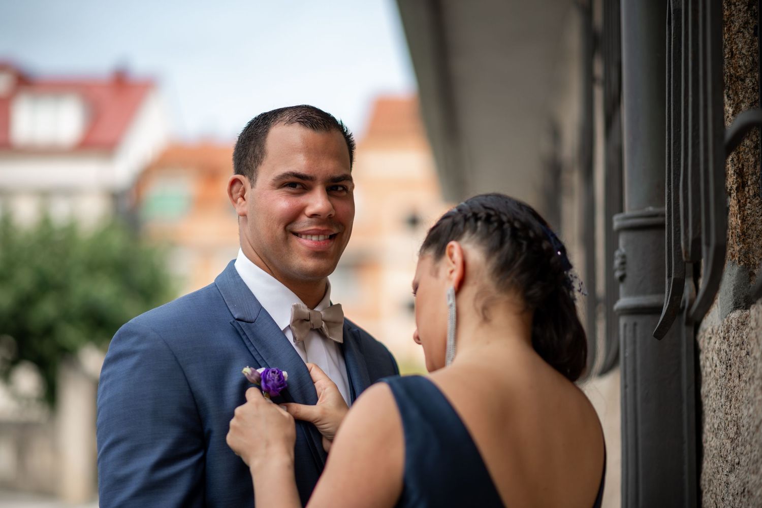 A romantic wedding couple shares an intimate moment outdoors in formal attire.