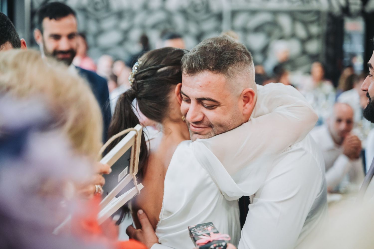 Guests celebrate and dance together at a lively indoor wedding reception.