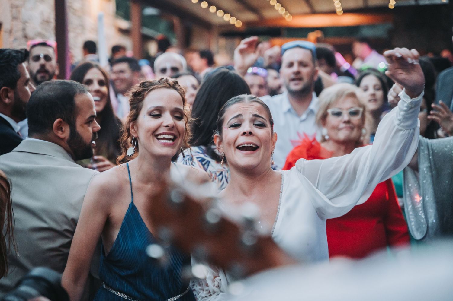 Joyful celebration with dancing and confetti at indoor wedding reception.