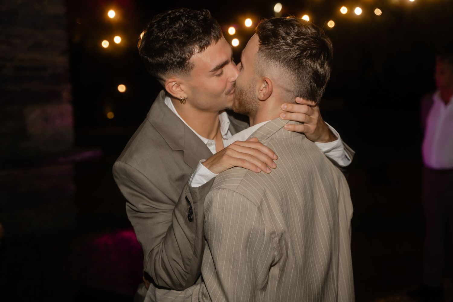 Intimate dance moment captured under warm string lights at an evening celebration.