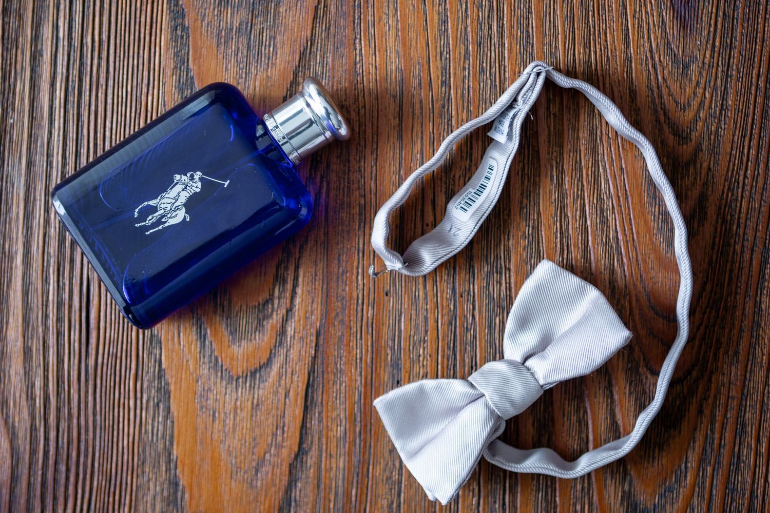 Rustic wooden table surface with white and navy blue ribbons scattered across the dark wood grain pattern.