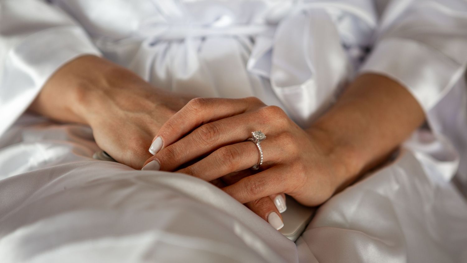 Diverse hands join together in unity showing support and connection in a bright white setting.