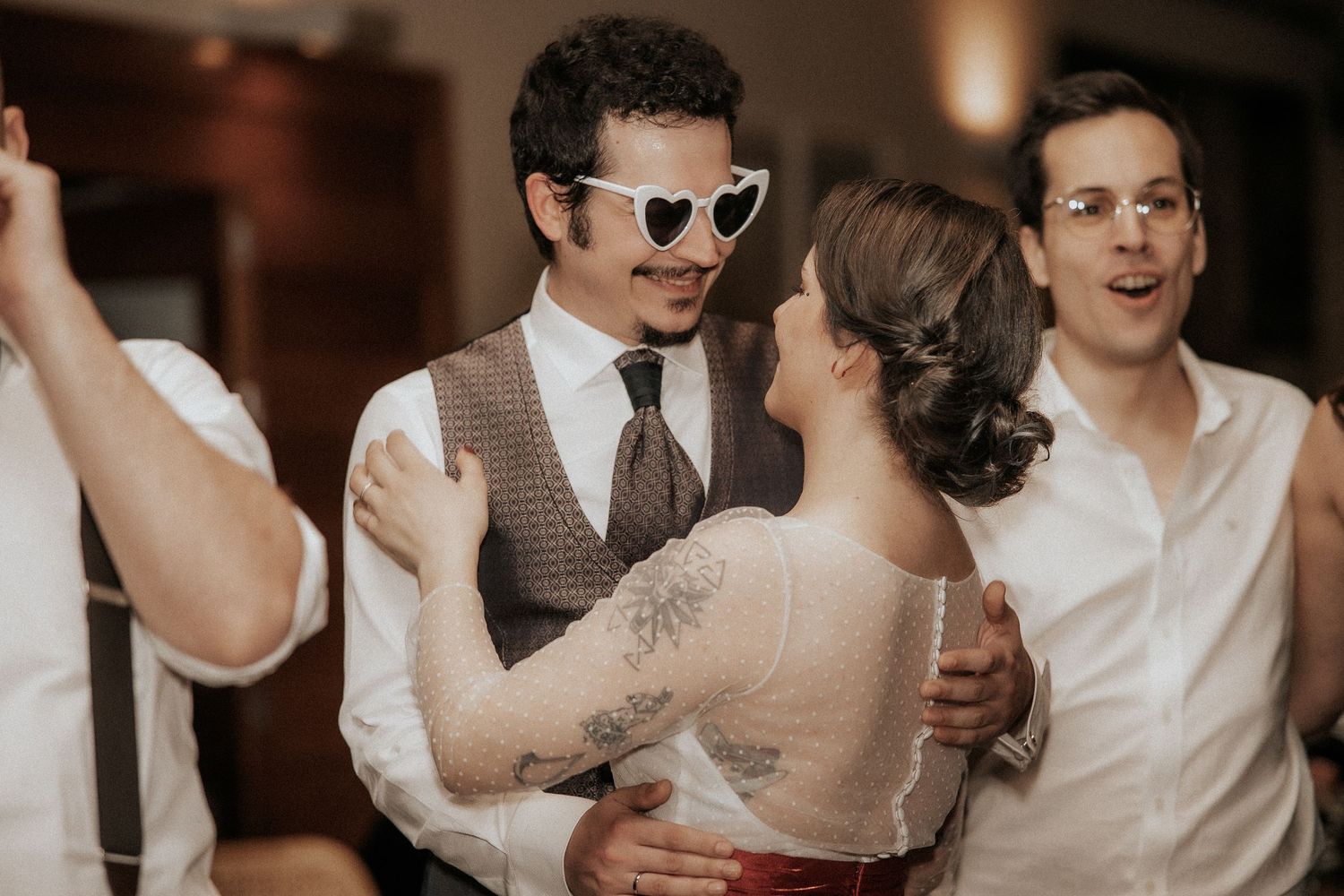 Wedding party members share joyful moments and laughter during a reception celebration.