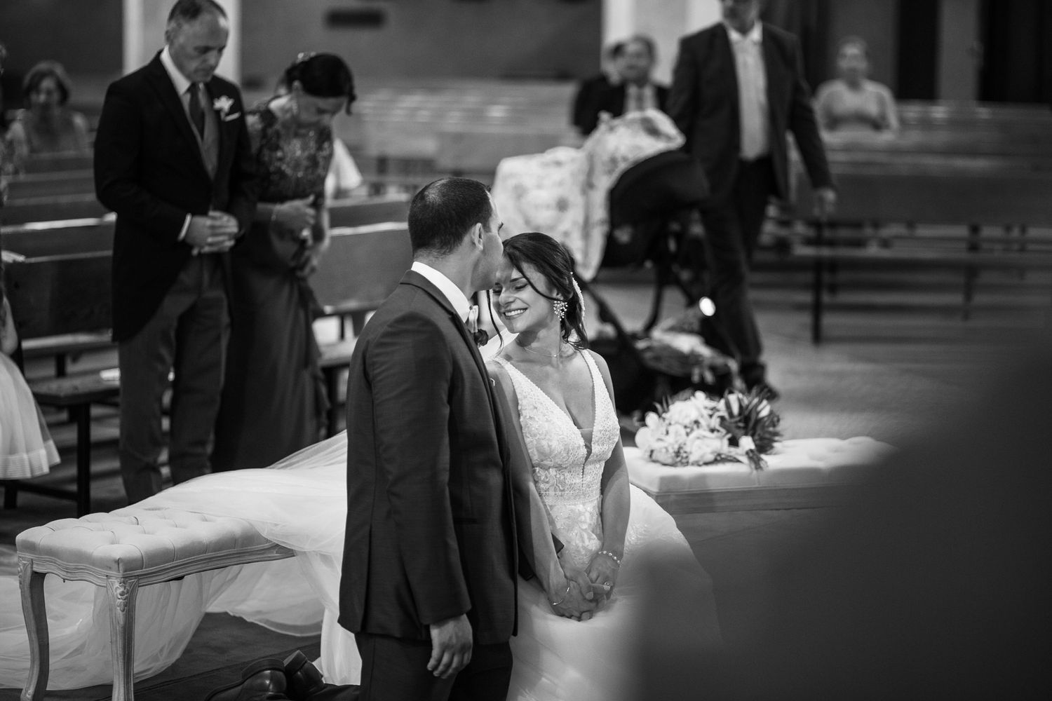 Black and white photo of a wedding couple sharing a tender moment.