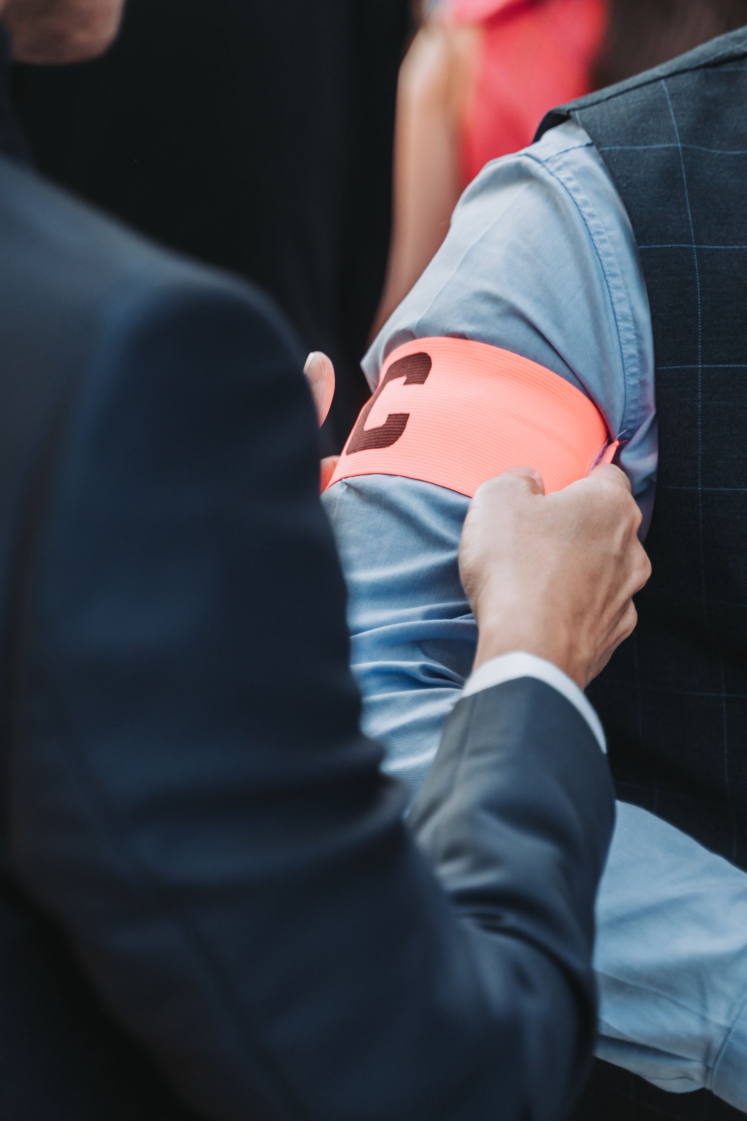 Close-up shot of hands holding red cups during a wedding celebration.