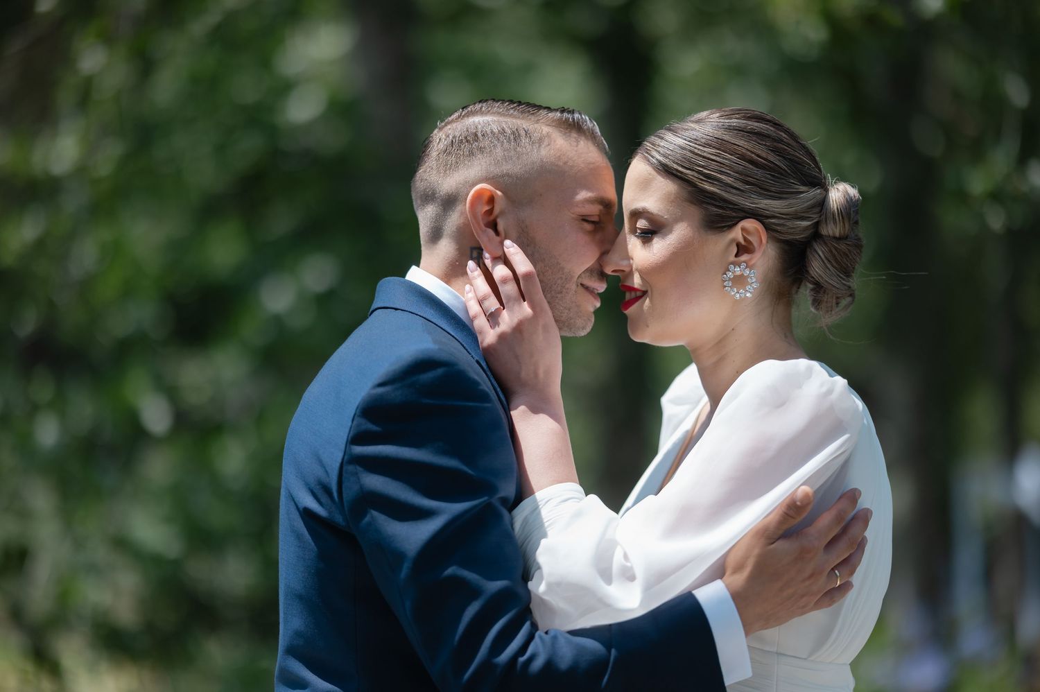 Romantic couple in formal wedding attire sharing intimate moments in a lush garden setting.