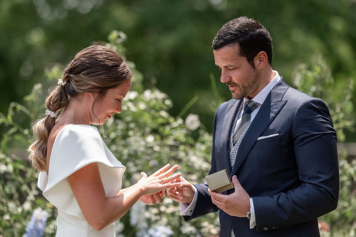 A couple exchanges vows during an intimate outdoor garden ceremony.