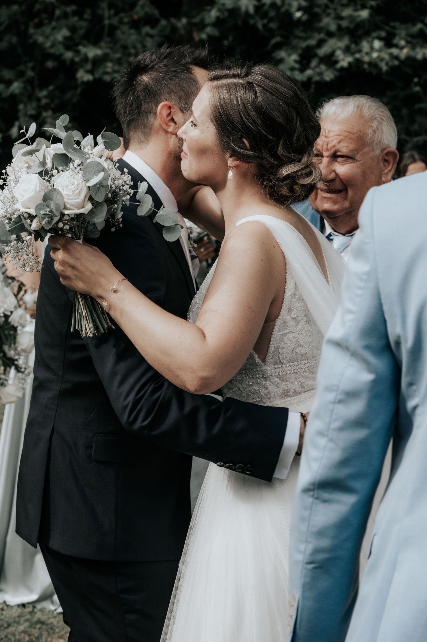 A romantic sequence of wedding photos showing a couple sharing their first kiss as newlyweds at an outdoor ceremony.