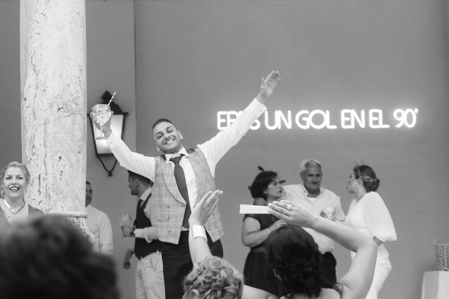Black and white collage of wedding moments showing joyful dancing and celebrations at a reception.