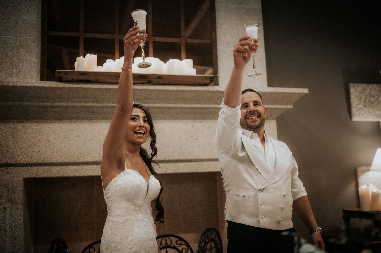 A couple dancing and twirling together during their wedding celebration in a dimly lit reception venue.