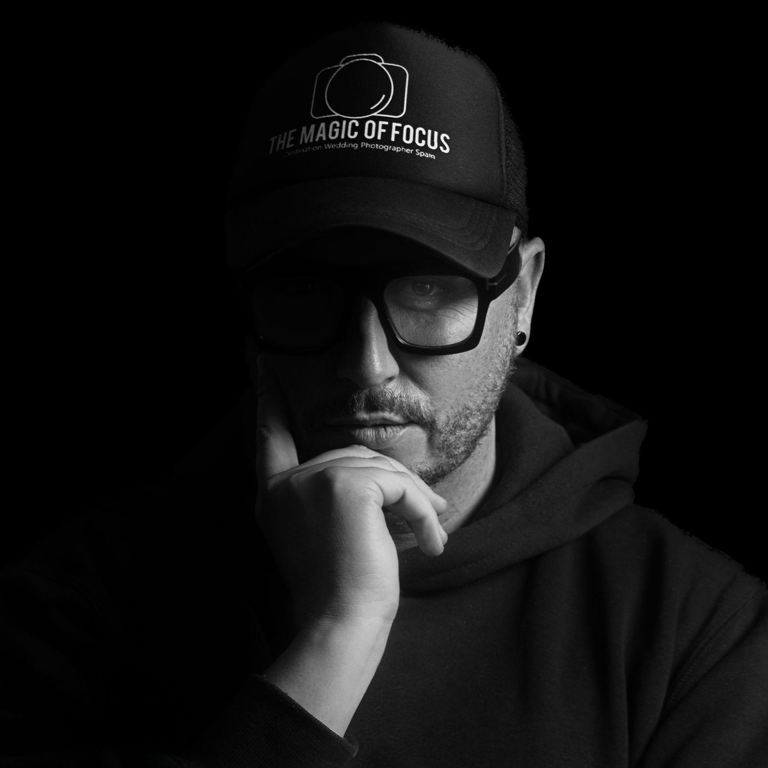 Black and white portrait series showing a person in a baseball cap and hoodie from different angles in dramatic lighting.