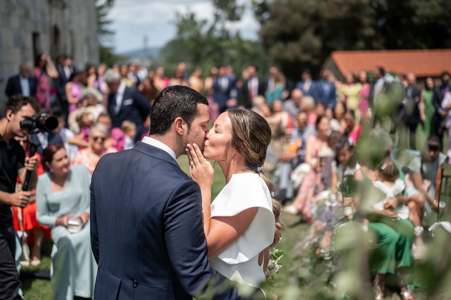 Wedding celebration in a garden setting with guests and red poppies in background.