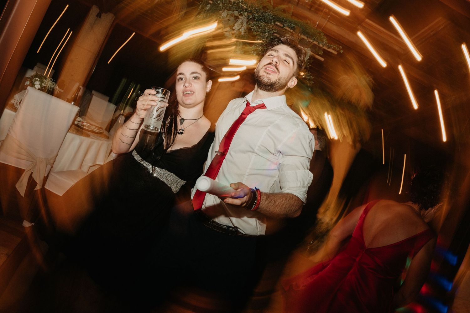Guests celebrating on a dance floor with warm lighting and festive atmosphere at a wedding reception.