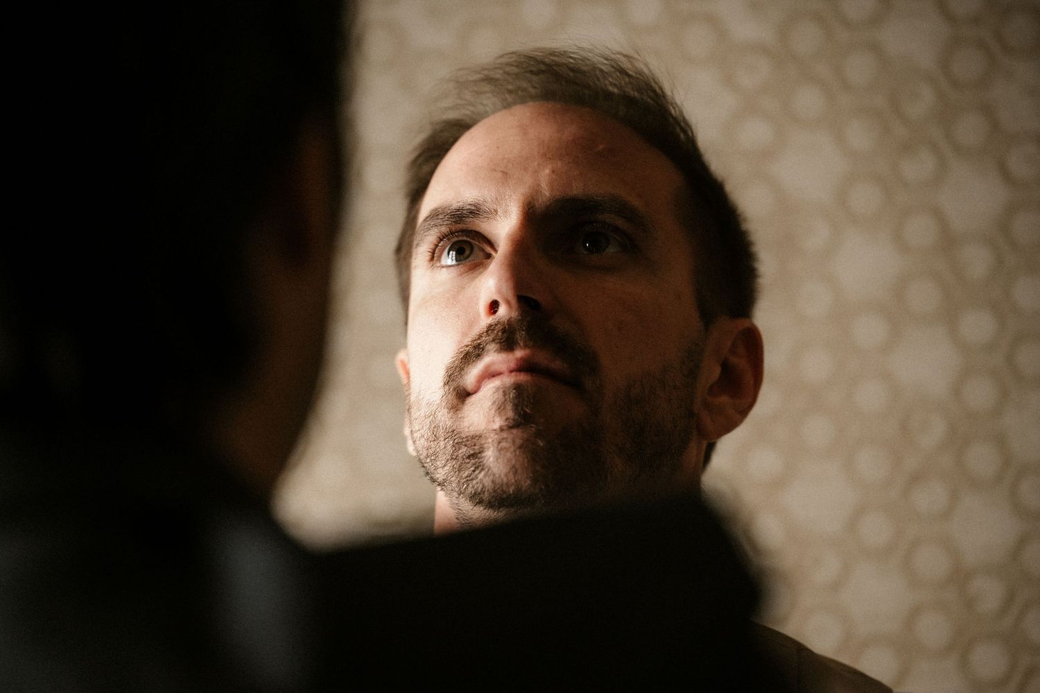 A series of moody profile portraits showing a person in dramatic lighting against a patterned background.