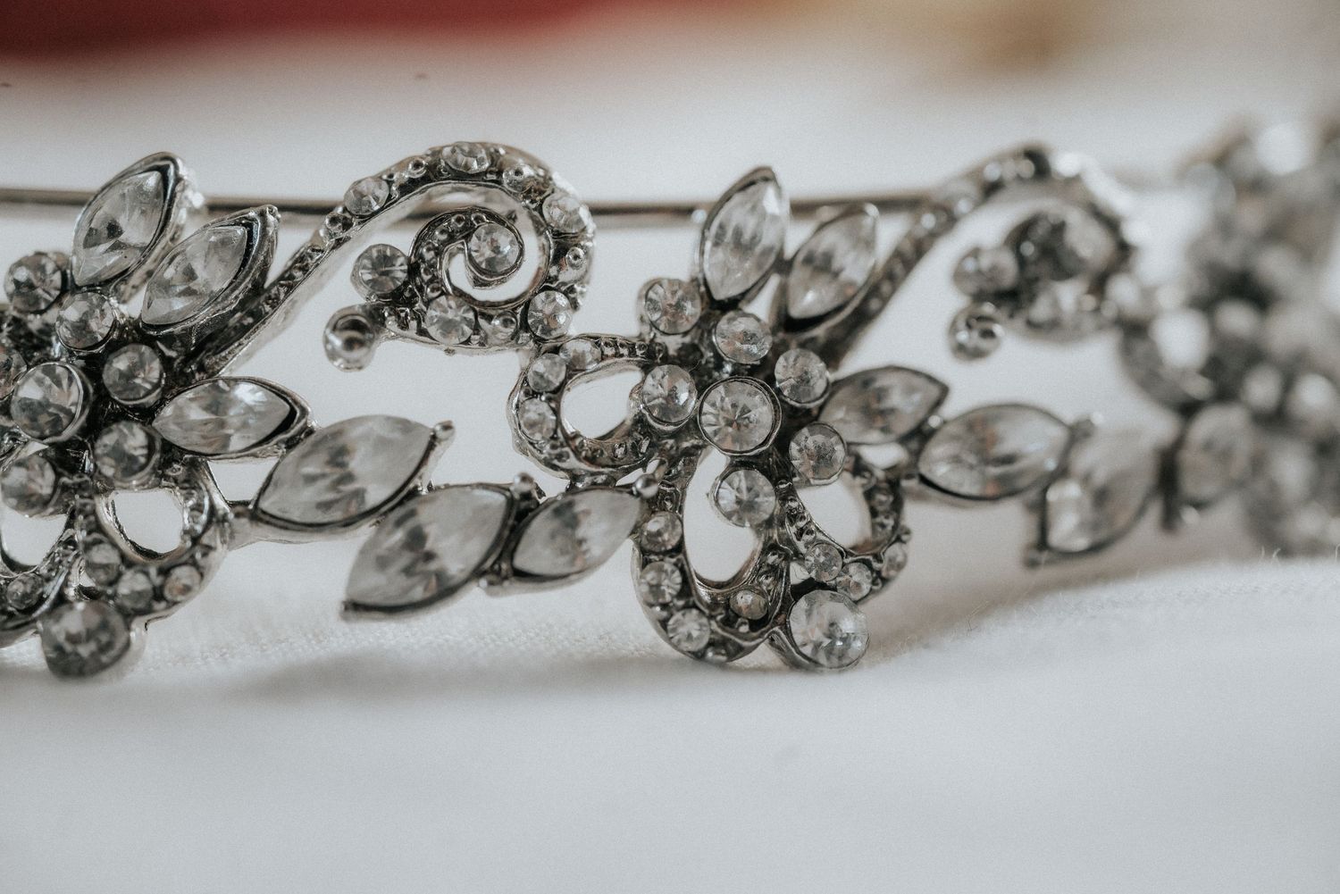 Elegant crystal and silver bridal jewelry pieces laid out in a row showing intricate details and sparkle.