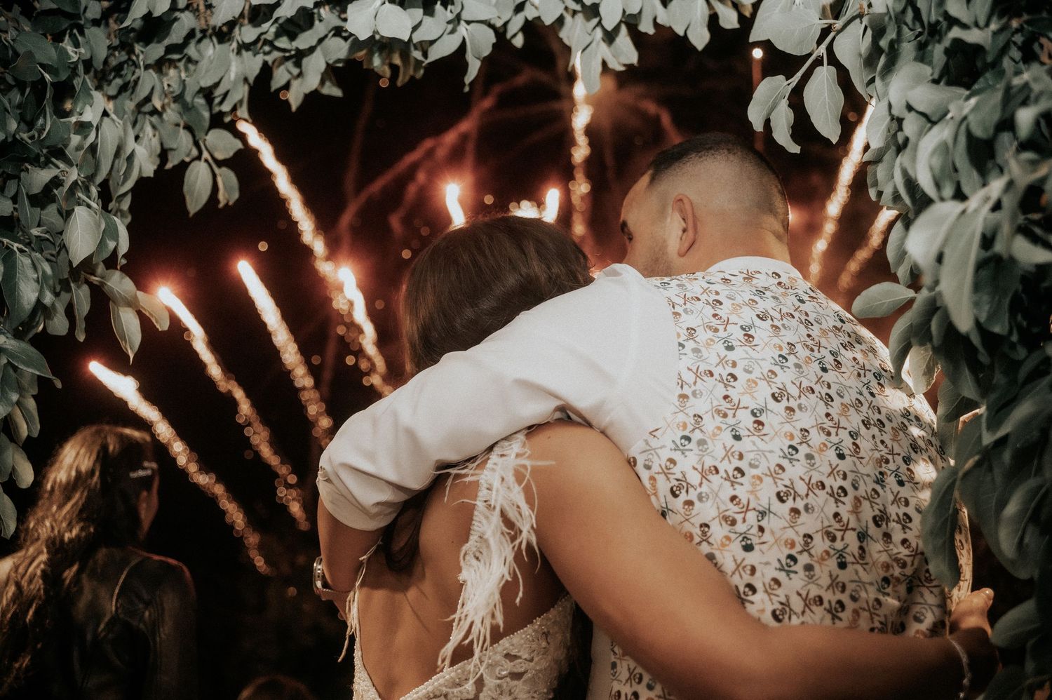 Romantic outdoor wedding scene with string lights glowing through tree branches at dusk creating a magical atmosphere.